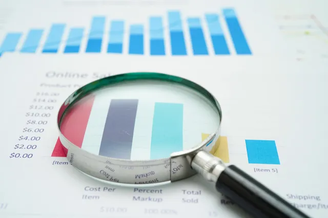 Magnifying glass on charts graphs paper. finance business.